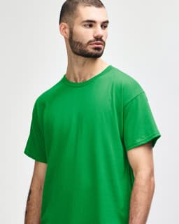 A green Gildan Heavy Cotton adult T-shirt displayed on a model. The shirt has a simple design and no visible logos.