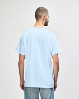 A light blue Gildan Heavy Cotton adult T-shirt displayed from the back, featuring a plain design and short sleeves.