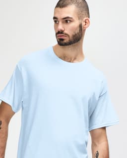 A light blue Gildan Heavy Cotton adult t-shirt is displayed on a model facing slightly to the side.