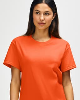 An orange Gildan Heavy Cotton Adult T-Shirt displayed on a model, featuring a simple design and logo.