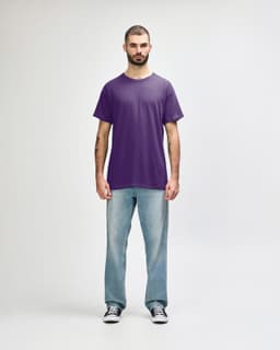 A purple Gildan Heavy Cotton Adult T-Shirt displayed on a model, paired with black jeans and casual shoes.