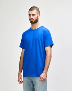 A blue Gildan Heavy Cotton Adult T-Shirt displayed on a model, featuring a brand logo.