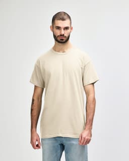 A light beige Gildan Heavy Cotton adult T-shirt worn by a male model, featuring a plain design and a logo.