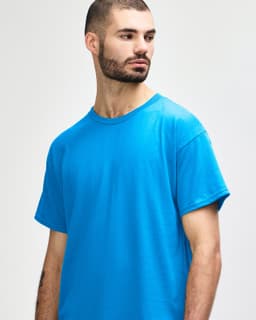 A plain turquoise adult t-shirt displayed on a model, featuring a simple design and a crew neck.