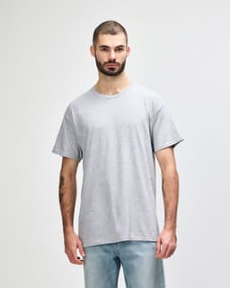 A grey T-shirt with a relaxed fit, featuring a logo on the front, displayed on a male model.