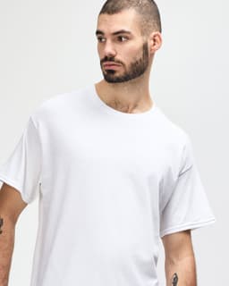 A white Gildan Heavy Cotton adult T-shirt displayed on a model wearing black jeans and sneakers.