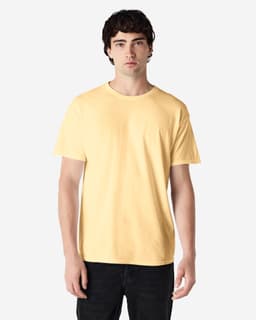 A model wearing a yellow Gildan Heavy Cotton adult T-shirt, paired with blue jeans. The shirt has a logo.
