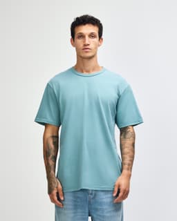 A sueded unisex short sleeve t-shirt in a soft blue colour, featuring a relaxed fit and a visible logo.
