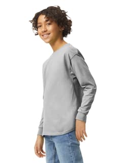 A youth long sleeve T-shirt in grey, featuring a logo, displayed on a model smiling at the camera.