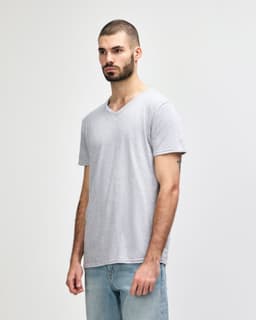 A grey Gildan Softstyle adult v-neck t-shirt displayed on a male model, featuring a logo on the shirt.