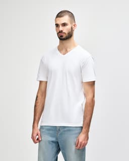 A man wearing a white Gildan Softstyle adult v-neck t-shirt, standing in profile against a plain background.