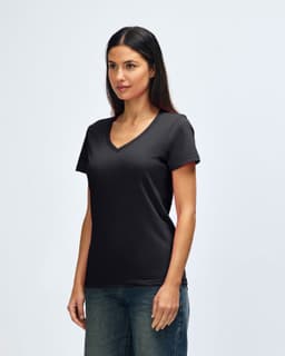 A black Gildan Softstyle ladies' V-neck T-shirt displayed on a model, paired with blue jeans.