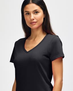 A black Gildan Softstyle ladies' V-neck T-shirt displayed on a model with straight hair. It features a logo.