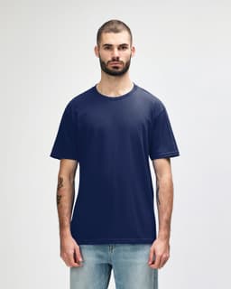 A navy blue midweight t-shirt on a model, featuring a simple design and a logo on the front.