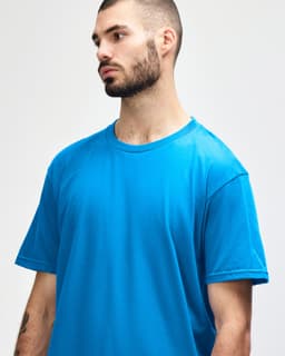 A bright turquoise adult midweight T-shirt on a model, featuring a round neckline and short sleeves.