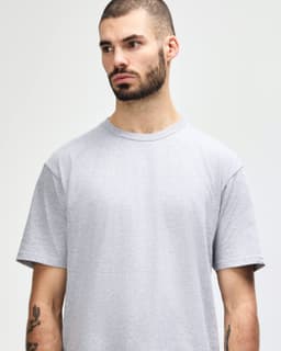A grey midweight T-shirt with a relaxed fit, featuring a brand logo.