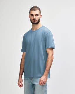 A light blue midweight t-shirt on a model, featuring a simple design and short sleeves. The shirt has a logo.