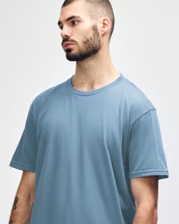 A light blue Gildan Softstyle adult midweight T-shirt featuring a crew neckline, displayed on a model.