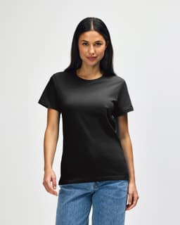 A black Gildan Softstyle ladies midweight t-shirt displayed on a model, featuring a simple design and a logo.