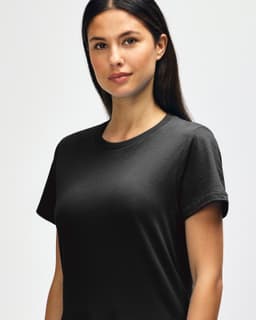 A black Gildan Softstyle ladies midweight T-shirt displayed on a model, featuring a crew neckline and short sleeves.