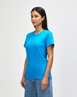 A bright turquoise ladies midweight t-shirt displayed on a model, paired with casual denim jeans.