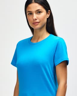 A blue Gildan Softstyle ladies midweight T-shirt displayed on a model with long brown hair.