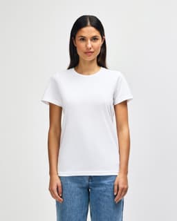 A white midweight t-shirt for ladies, featuring a classic fit and short sleeves. The model is wearing jeans.