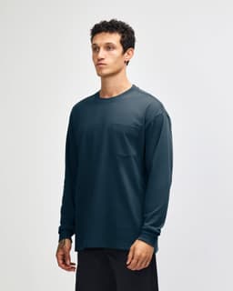 A long-sleeve navy T-shirt with a pocket and a logo. The model is wearing casual olive green pants.