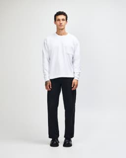 A model wearing a white American Apparel Super Heavyweight T-Shirt paired with olive green cargo pants.