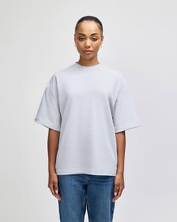 A grey oversized unisex boxy top made from French terry fabric, featuring short sleeves and a round neckline.