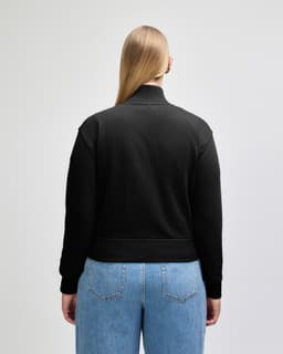 A black women's full-zip jacket made of French terry fabric, featuring a logo.