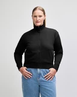 A woman wearing a black full-zip jacket with a high collar. The jacket has a logo on it.
