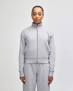 A grey full-zip jacket with a stand collar, featuring a fitted design and long sleeves. Contains a logo.