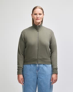 A women's full-zip jacket in olive green, featuring a high collar and ribbed cuffs, with a logo visible.