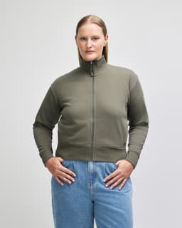 A women's full-zip jacket in olive green, featuring a high collar and ribbed cuffs, with a logo on the sleeve.