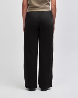 Wide-leg pants in black, featuring an elastic waistband and a smooth back design. Includes a logo.
