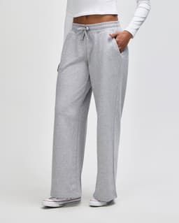 Wide leg pants in light grey featuring a drawstring waist and side pockets. The model is wearing a long-sleeve top.