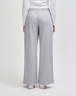 Grey women's wide leg pants with an elastic waistband, featuring a logo on the back.
