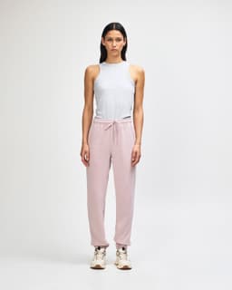 A pair of pink unisex sweatpants made from fleece, featuring a logo and side pockets.