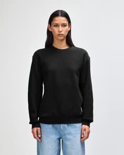A unisex crewneck sweatshirt in black, featuring long sleeves and a relaxed fit. The garment has a logo present.