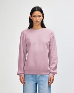 A unisex crewneck sweatshirt in a soft lilac colour, featuring long sleeves and a relaxed fit. It has a small logo.
