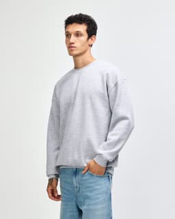 A unisex crewneck sweatshirt in light grey, featuring a relaxed fit and ribbed cuffs. It has a logo on it.