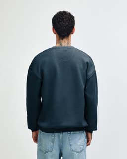 A unisex crewneck sweatshirt in dark blue, featuring a plain design and a logo on the back.