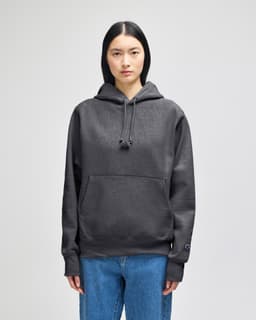 A hooded sweatshirt in dark grey, featuring a front pouch pocket and a subtle logo.