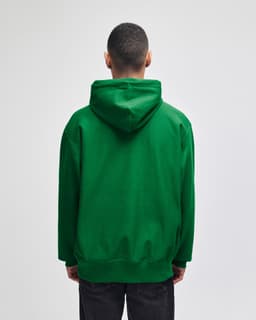 A green pullover hooded sweatshirt with a kangaroo pocket and a hood, seen from the back.