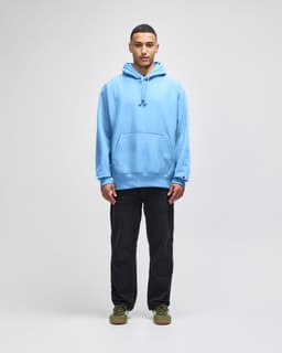 A light blue hooded sweatshirt with a front pocket, worn by a model standing against a neutral background.