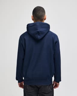 A navy blue pullover hooded sweatshirt with a logo on the back, featuring a relaxed fitting design.