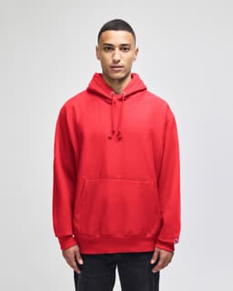 A red pullover hooded sweatshirt with a front pocket and a logo on the sleeve.