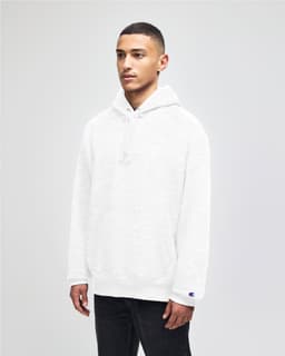 A white pullover hooded sweatshirt with a front pocket and a logo on the sleeve, worn by a model.