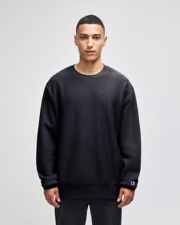 A black crew sweatshirt made from heavy fabric, featuring a logo on the sleeve.